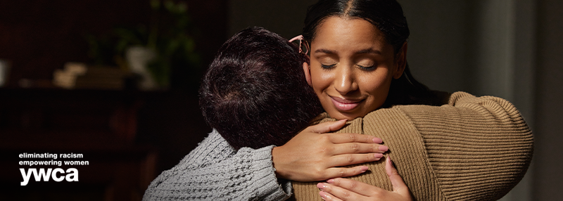 Woman smiling and hugging another person