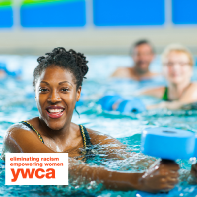Woman smiling while holding weights during aqua aerobics class
