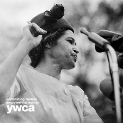 Black and white of Rosa Parks speaking into microphones on a podium 