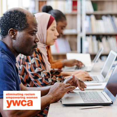 People of various races and cultures sitting at desk using laptops